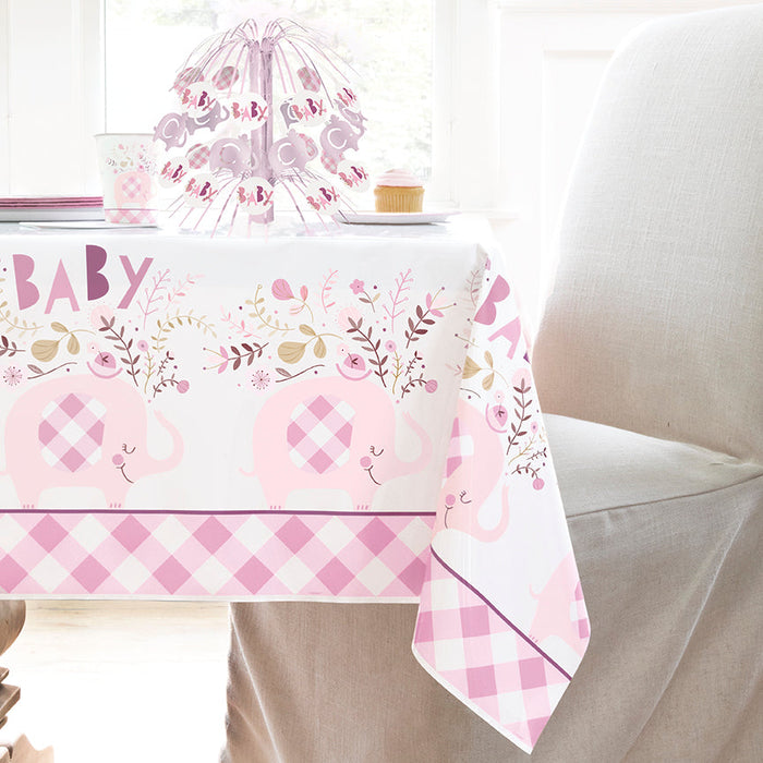 Pink floral elephant baby shower table cover featuring a repeating “Baby” design, pink elephants with gingham ears, floral accents, and matching party items on a bright table setup.