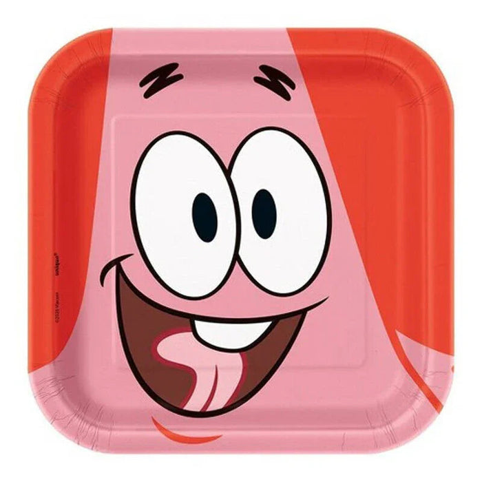 Pink square paper dessert plate featuring a smiling cartoon character face with large round eyes, wide grin, and red hair, measuring 7 inches.