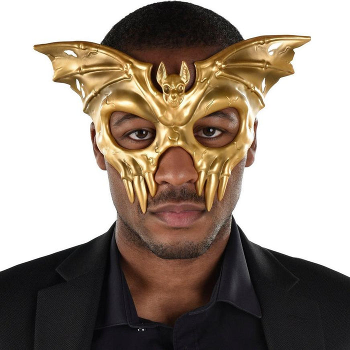 A man wearing a Adult Gold Winged Skull Plastic Half Mask.