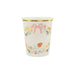 Cream-colored paper cup with gold rim featuring watercolor floral garland, pink bow, and strawberry illustrations around the sides.