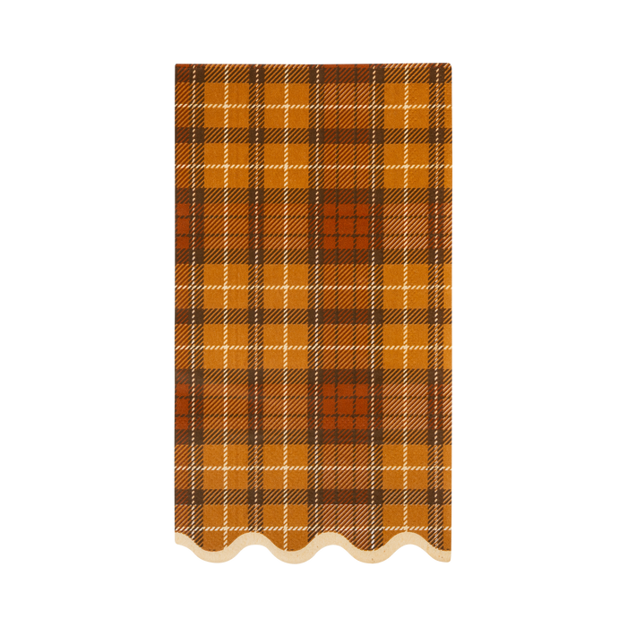 Plaid patterned napkin with a scalloped edge on a white background