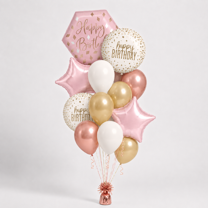A birthday balloon bouquet featuring metallic rose gold,  gold, white, and pink balloons, including star and round foil balloons with 'Happy Birthday' text, arranged on a light gray background.