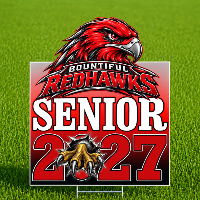 A rectangular Bountiful Redhawks senior 2027 yard sign displayed on a green grass lawn. The sign features a red hawk mascot head, the text 'BOUNTIFUL REDHAWKS', 'SENIOR', and '2027' in bold red and white lettering, with a graphic of a hawk's claw tearing through the number 2.