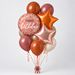 A balloon bouquet featuring a pink foil balloon with 'happy birthday' text, metallic orange and rose gold star balloons, matte orange and dusty rose round balloons, and cream balloons, tied together with ribbons on a light gray background.