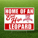 Home of an East High Leopard yard sign featuring bold red and white school colors, large white "HOME OF AN" and "LEOPARD" text, a script-style "East High" across the center, and the East High Leopards logo on a corrugated plastic yard sign with an H-stake for outdoor display.
