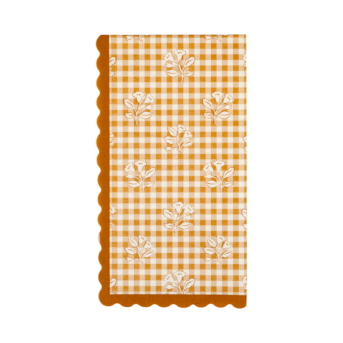 Decorative paper napkin with orange and white checkered pattern and floral designs on a white background