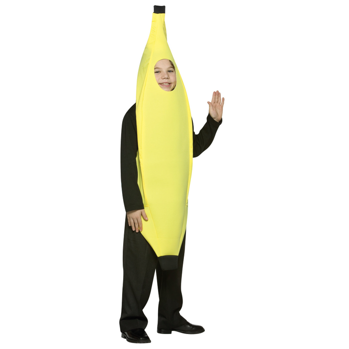 A child wearing a banana costume with a bright yellow banana-shaped body, black sleeves and pants, standing against a plain white background and waving one hand.