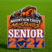 A rectangular yard sign with a die-cut design featuring an orange mustang horse over mountains, the text 'MOUNTAIN CREST MUSTANGS', 'SENIOR', and '2027' on a green grass background.
