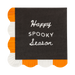 Black napkin with 'Happy Spooky Season' text, surrounded by orange and white scalloped edges