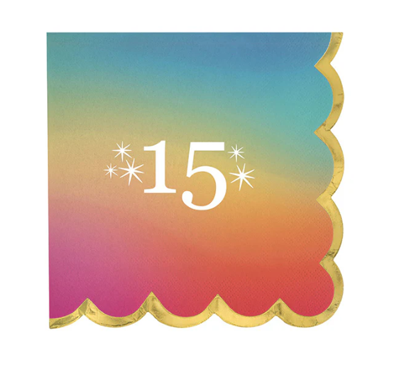 Square beverage napkin with rainbow gradient background, gold scalloped edge, and white “15” milestone number with star accents, shown on a white background.