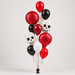 A cluster of Halloween-themed balloons, including red foil round balloons, white, red and black latex balloons, and two white skull foil balloons, photographed against a light gray studio background.