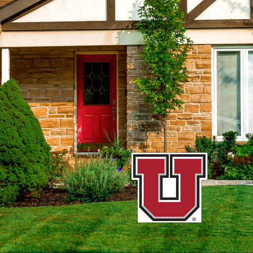 A 23-inch U of U Block U Shape Cut Yard Sign displayed in a yard in front of a house..