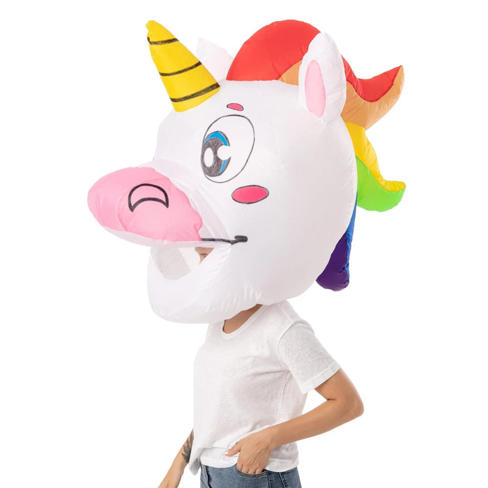 Person wearing a white inflatable unicorn head costume with a yellow striped horn, pink ears, rainbow mane, large blue eye, and pink nose, paired with a white t-shirt.