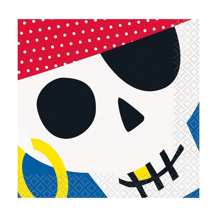 Colorful paper napkin featuring a pirate skull design with black eye sockets and stitched mouth, red polka-dotted bandana, yellow and blue accents, and geometric shapes in corners.