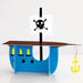 Blue cardboard pirate ship with three yellow windows, black mast with skull and crossbones flag, and yellow anchor hanging from the side.