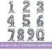 Silver foil self-standing number balloons in 54-inch size, displaying digits 0 through 9 with reflective metallic finish and built-in bases for upright display.
