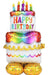 Colorful inflatable birthday cake balloon with five lit candles on top, rainbow polka dots, "Happy Birthday" text in multicolored letters, scalloped garland trim, and gold foil balloon base decorations.