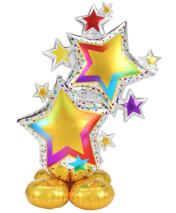 Colorful foil balloon featuring two large yellow stars with gradient edges in magenta, purple, and cyan, surrounded by smaller stars in various colors, with a confetti-patterned silver border and gold balloon base.