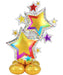 Colorful foil balloon featuring two large yellow stars with gradient edges in magenta, purple, and cyan, surrounded by smaller stars in various colors, with a confetti-patterned silver border and gold balloon base.