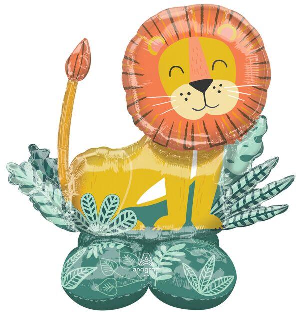 Uninflated foil balloon shaped like a smiling yellow lion with an orange mane, surrounded by green leaf decorations and a matching green base with a bow.