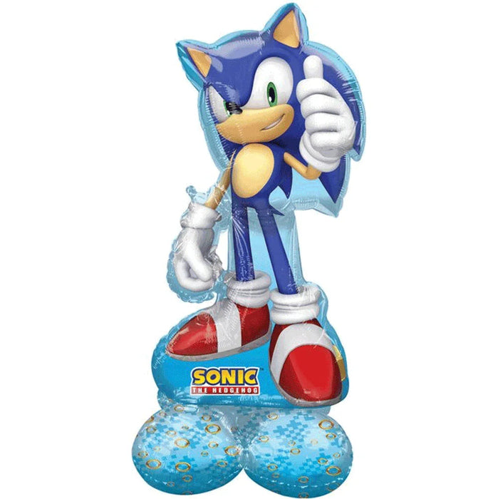 Blue foil balloon shaped like Sonic the Hedgehog with a thumbs-up gesture, featuring his signature blue body, white gloves, and red shoes, with "Sonic the Hedgehog" text on the base and blue balloons attached at the bottom.