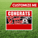 Graduation-themed sign with 'Congrats Grad 2026' on a grass background