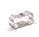 Silver metal dog bone-shaped cookie cutter with rolled edges and an American flag design printed on the top surface.