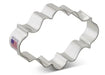 Silver metal oval plaque-shaped cookie cutter with wavy scalloped edges and a small American flag label on the side.