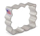White metal cookie cutter with wavy scalloped edges in a plaque shape, marked "Made in USA" with American flag on the tag.