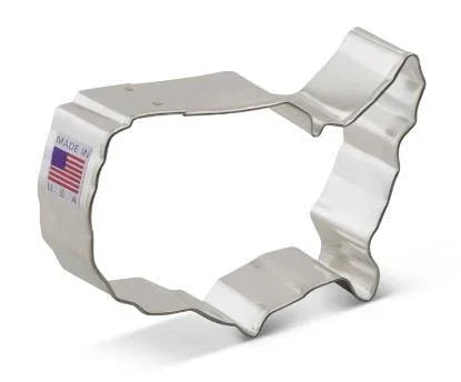 White metal USA map-shaped cookie cutter with American flag label, displayed at an angle against a white background.