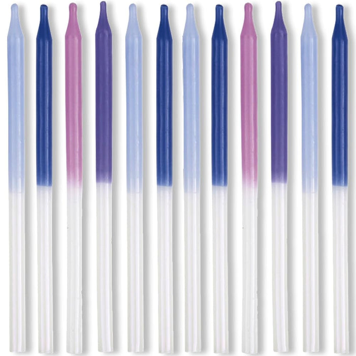 Twelve slender birthday candles with white lower bodies and iridescent dipped tops in shades of lavender, navy blue, and mauve arranged in a row.