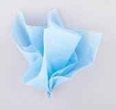 Crumpled sheets of light blue tissue paper arranged in a loose pile against a white background.