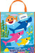 Colorful tote bag featuring cartoon sharks in orange, blue, pink, and yellow with large eyes, surrounded by underwater plants and fish on a bright blue background, with orange handles and a product tag attached.