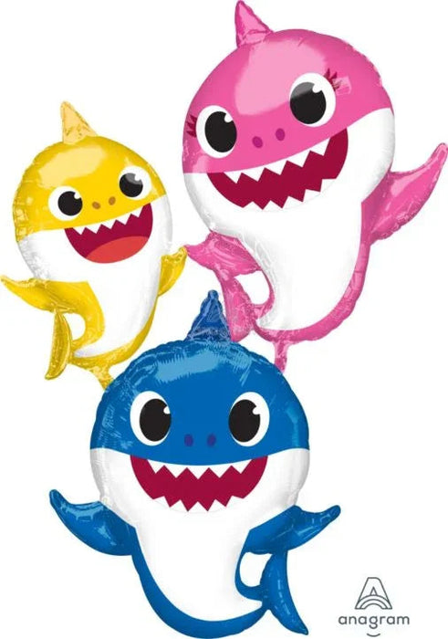 Three smiling shark character balloons in yellow, pink, and blue stacked together with big eyes and open mouths showing teeth.