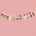 Gold and cream letter banner spelling "BEST MUM EVER" strung across a pink wall with ten printed photos clipped to the string.