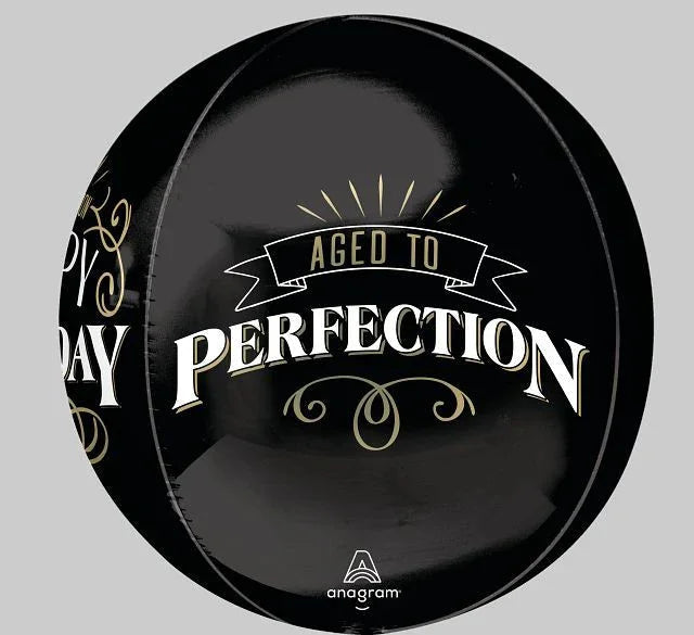 Black spherical foil balloon with gold and white text reading "Aged to Perfection" and decorative flourishes, with partial text visible on the left side.