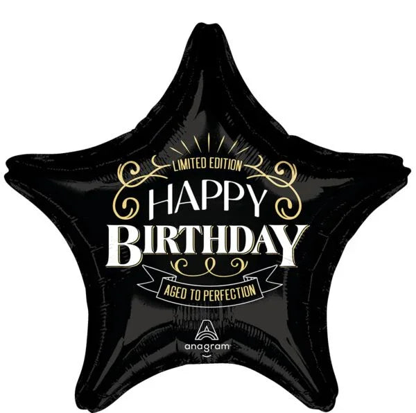 Black star-shaped foil balloon with gold and white "Happy Birthday" text and "Aged to Perfection" banner on a dark background.