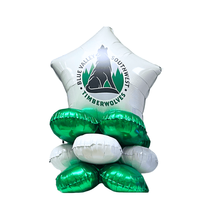 Stacked arrangement of four mylar balloons featuring a white star-shaped balloon at top with Blue Valley Southwest Timberwolves logo and green pine tree designs, flanked by green metallic oval balloons and a white oval balloon in the center.