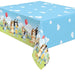 Blue rectangular plastic tablecloth featuring animated cartoon dogs in a grassy outdoor scene with balloons, white clouds on blue background, and cloud pattern on top surface.