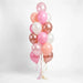 Vertical bouquet of sixteen balloons in shades of blush pink, rose gold, white, and peach with metallic finishes, gathered at the base with curled ribbon streamers.