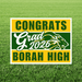 Yellow and green yard sign for Borah High School class of 2026 with a cougar mascot logo and white text reading "Congrats Grad" displayed on grass.