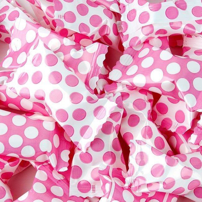 Multiple pink and white polka dot fabric pouches with ruffled edges arranged in an overhead view display.