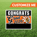 Graduation-themed sign with 'Congrats Grad 2026' on a grass background