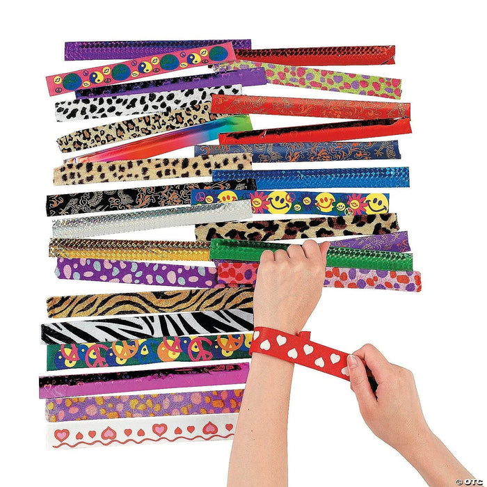 Child's hands wearing and holding colorful patterned slap bracelets in designs including leopard print, zebra stripes, smiley faces, hearts, polka dots, and floral patterns among approximately 50 assorted bracelets displayed fanned out.