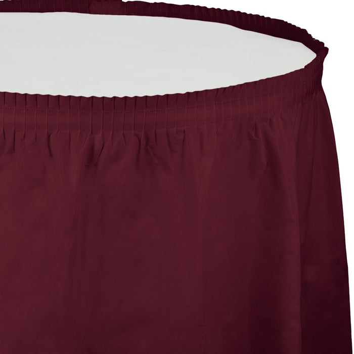 Burgundy pleated table skirt with elastic waistband shown laid flat against a white background.
