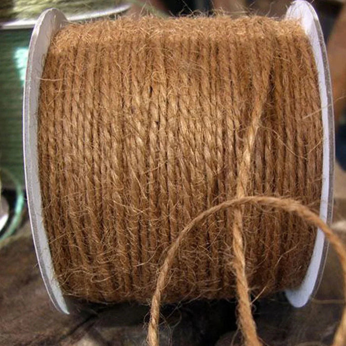 Roll of natural tan burlap jute twine wound on a white spool with a loose strand hanging down.