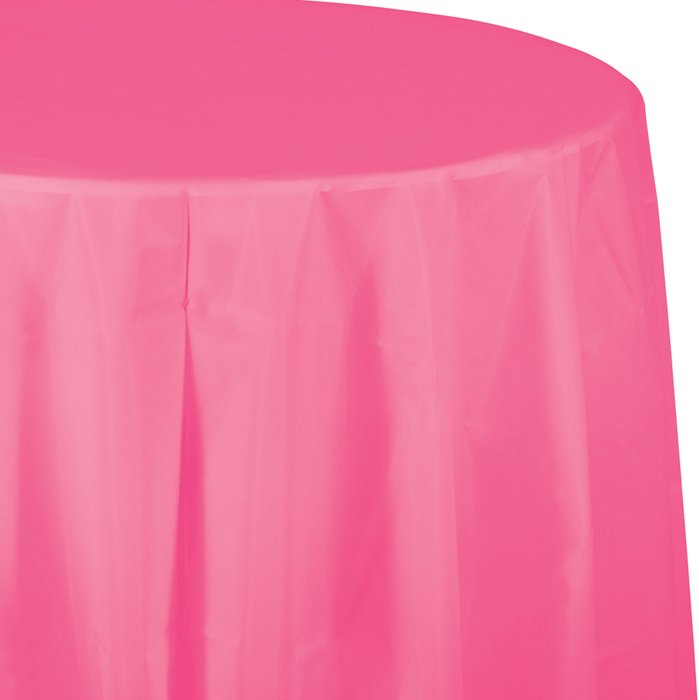 Bright pink round tablecloth draped over a table, showing the fabric's smooth texture and graceful folds cascading down the sides.