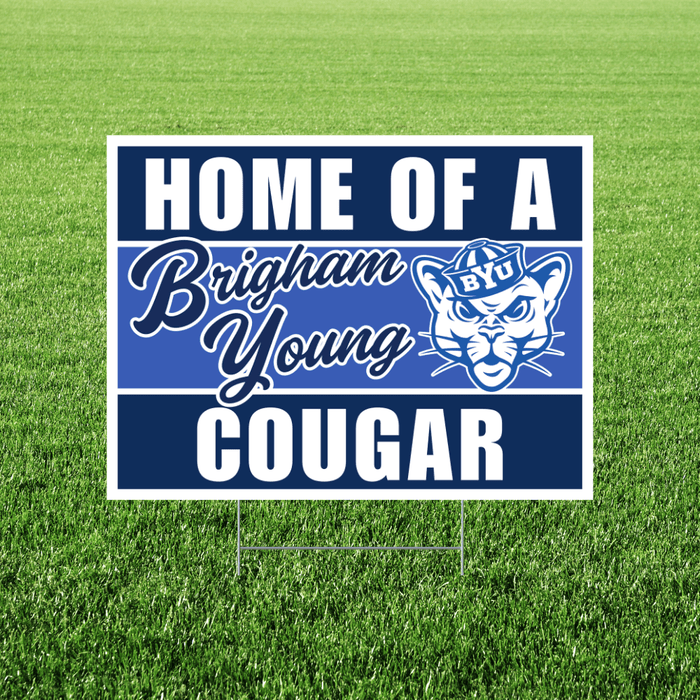 Navy and white yard sign with "HOME OF A Brigham Young COUGAR" text and a cougar mascot logo featuring a BYU hat, displayed on green grass.