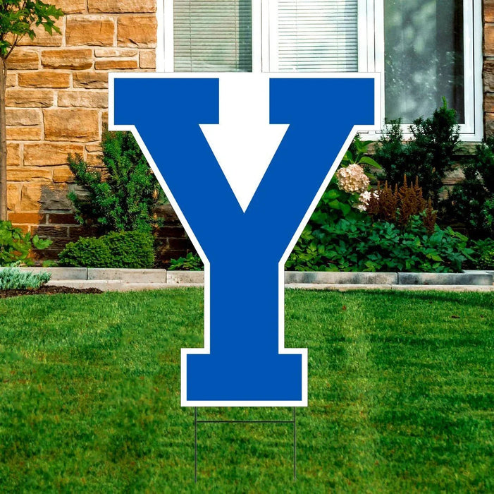 Blue and white Y-shaped yard sign displayed on a residential lawn with stone house and landscaping in the background.