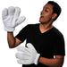 White oversized cartoon gloves with rounded fingers displayed on a man wearing a black v-neck shirt against a white background.
